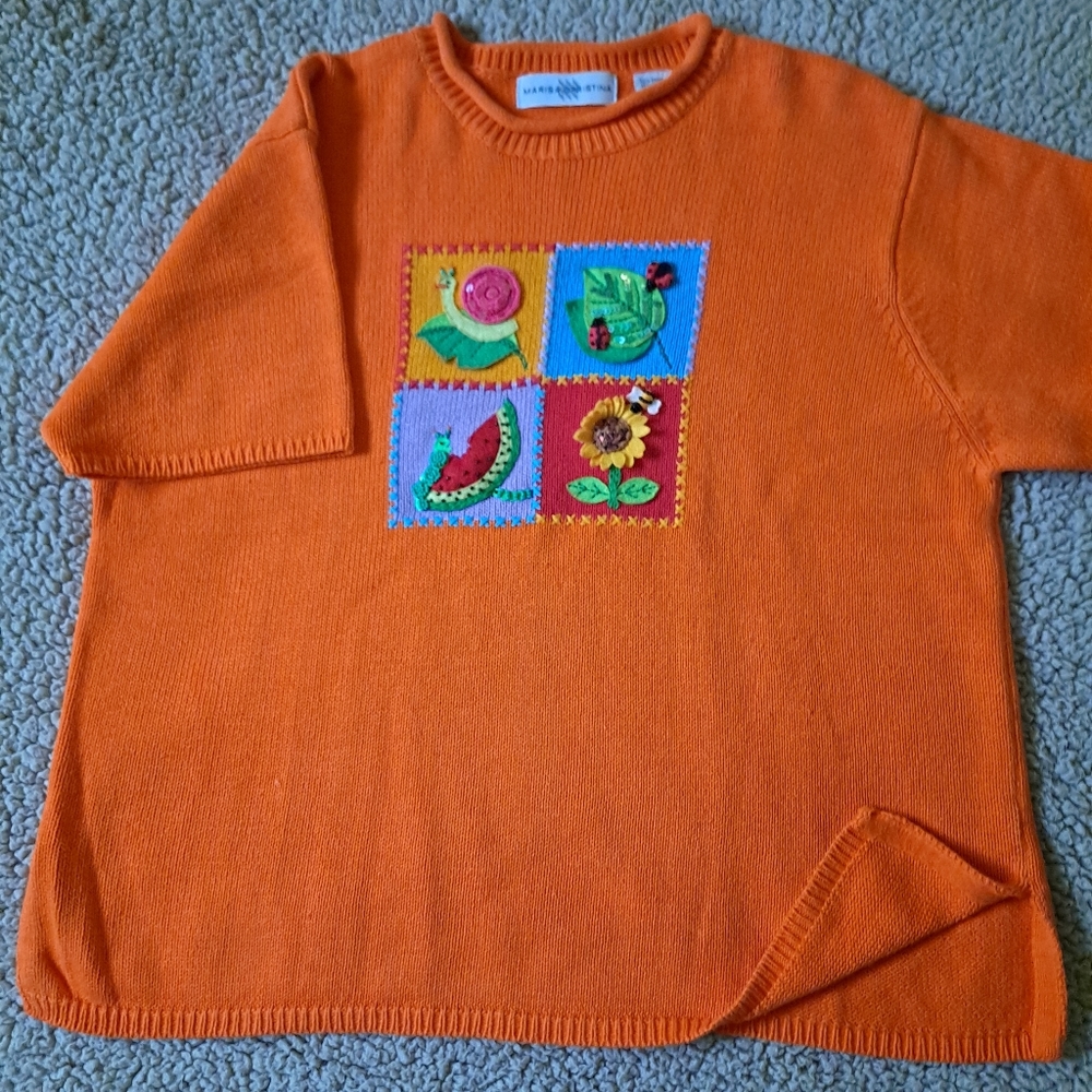 Sweater with colorful appliques.